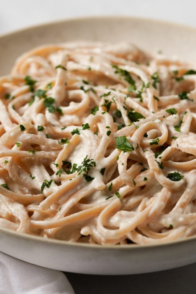 close up shot of a bowl of linguini pasta topped with greek yogurt cream sauce