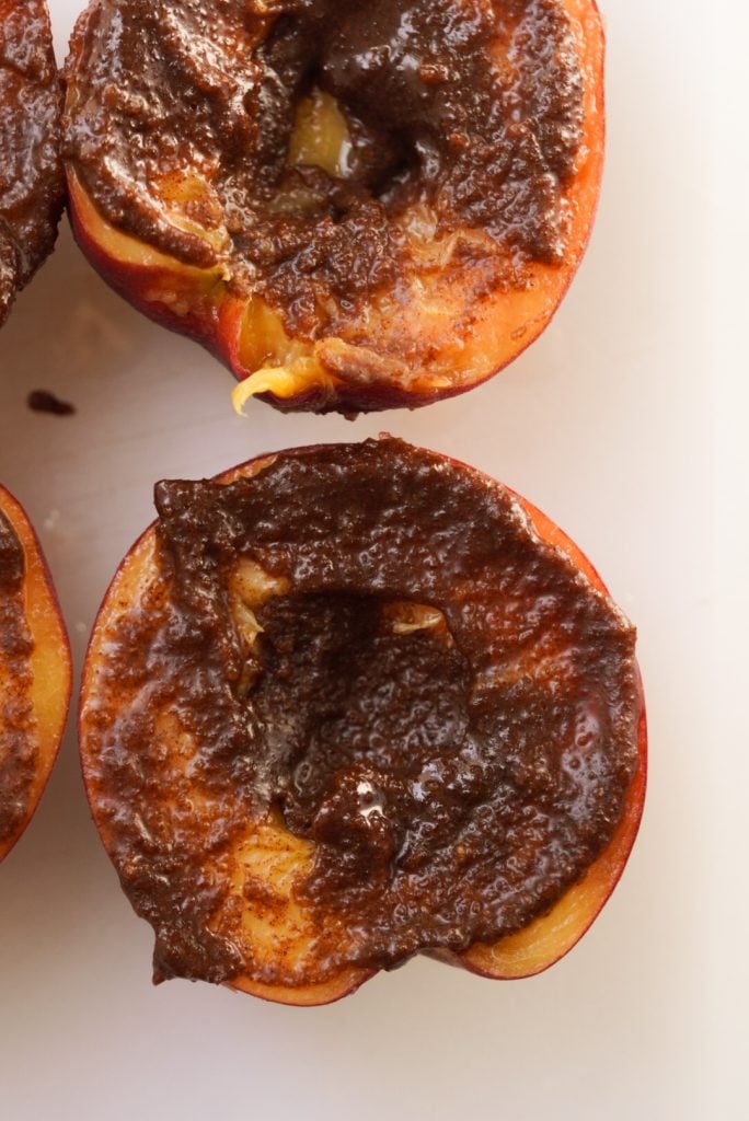 closeup overhead shot of a halved peach topped with cinnamon sugar mixture.