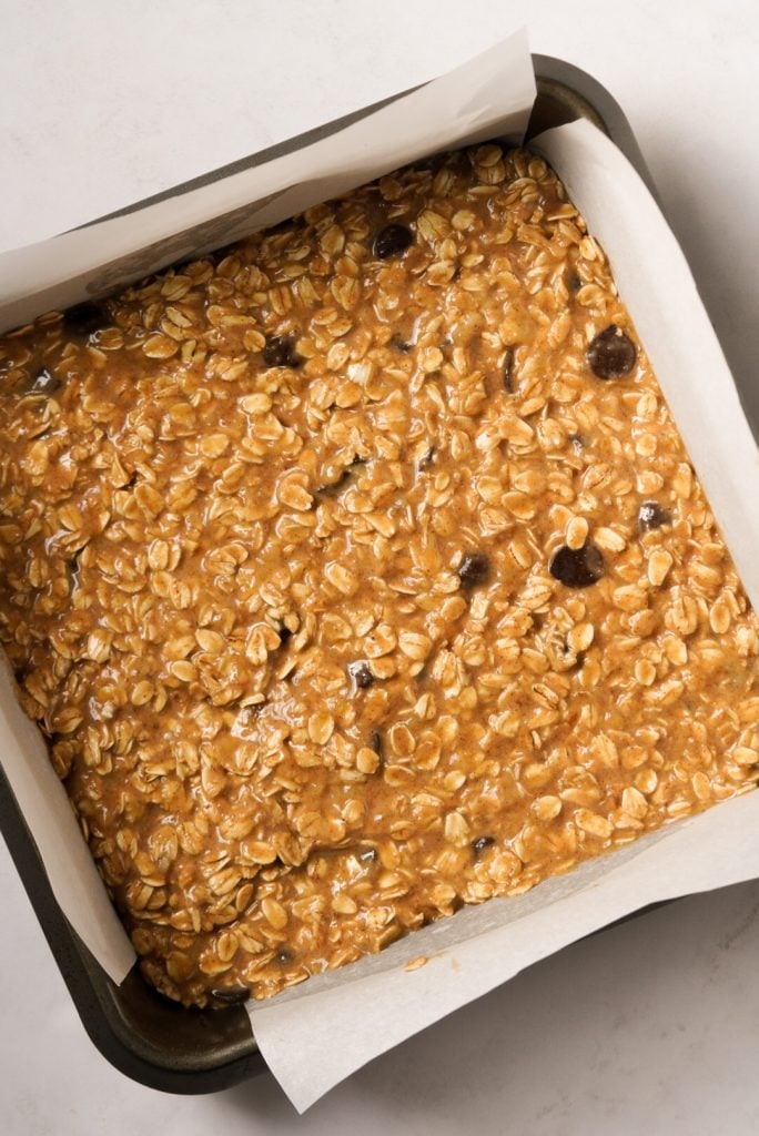 Peanut butter oat bar batter added to prepared baking tin.