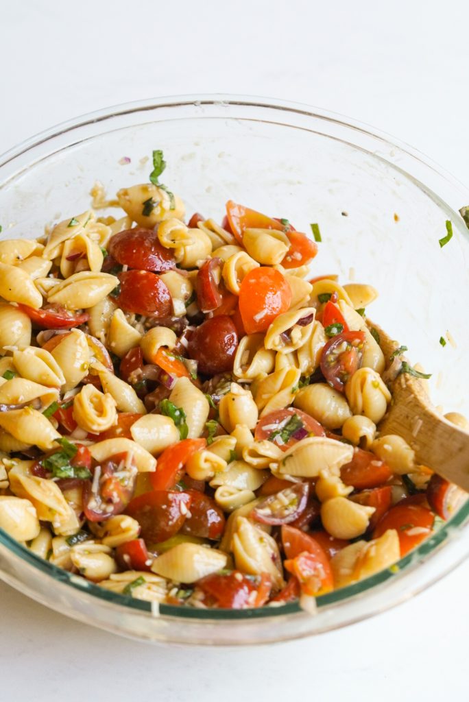 step 2 of making fresh tomato bruschetta pasta salad is tossing everything together to coat.