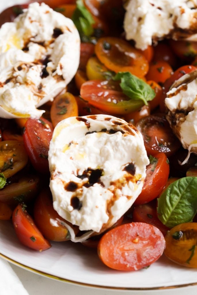 closeup shot of burrata drizzled with balsamic vinegar and evoo.