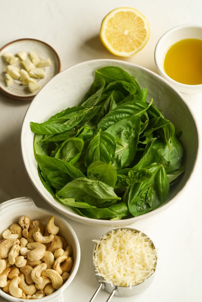 ingredients needed to make cashew basil pesto without pine nuts measured out on a table.
