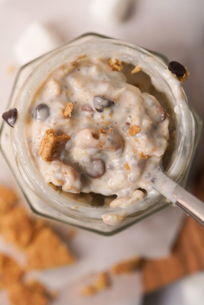 overhead shot of a spoonful of s'mores overnight oats coming out of a jar