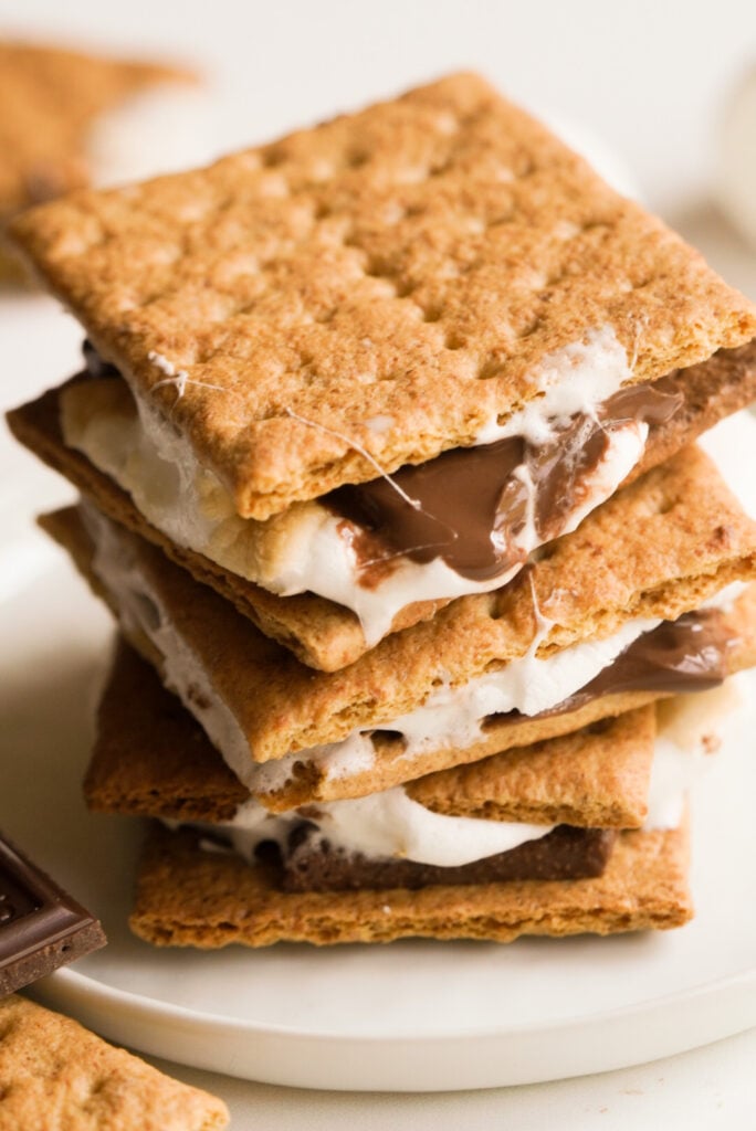 stack of three air fryer s'mores with melty marshmallow and chocolate oozing out