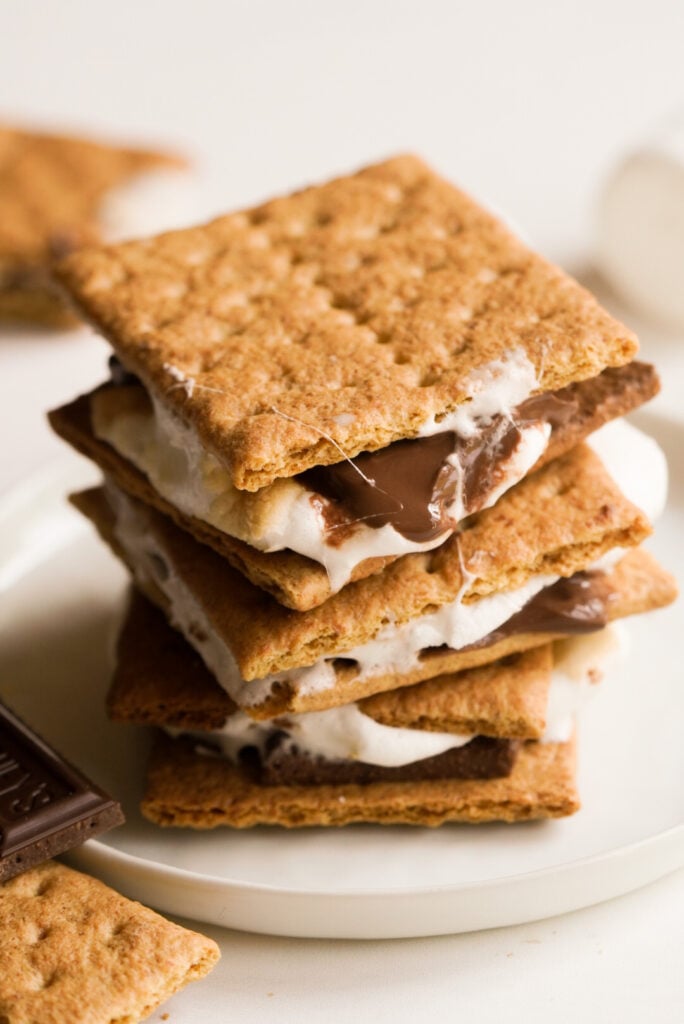 a stack of three ooey-gooey air fryer s'mores on a white plate 