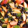 hero shot of a bowl of stone fruit berry salad.