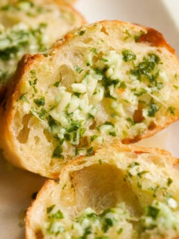 closeup shot of garlic bread slice with tons of garlic butter.