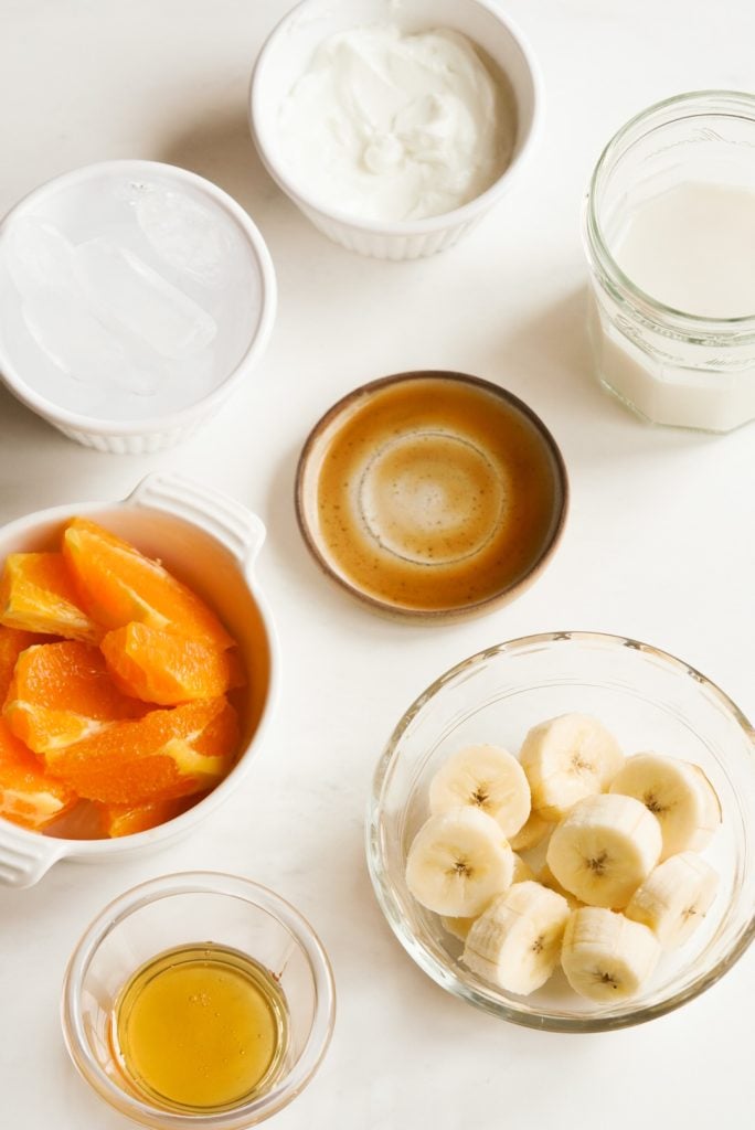 tropical inspired smoothie ingredients measured out on a white table