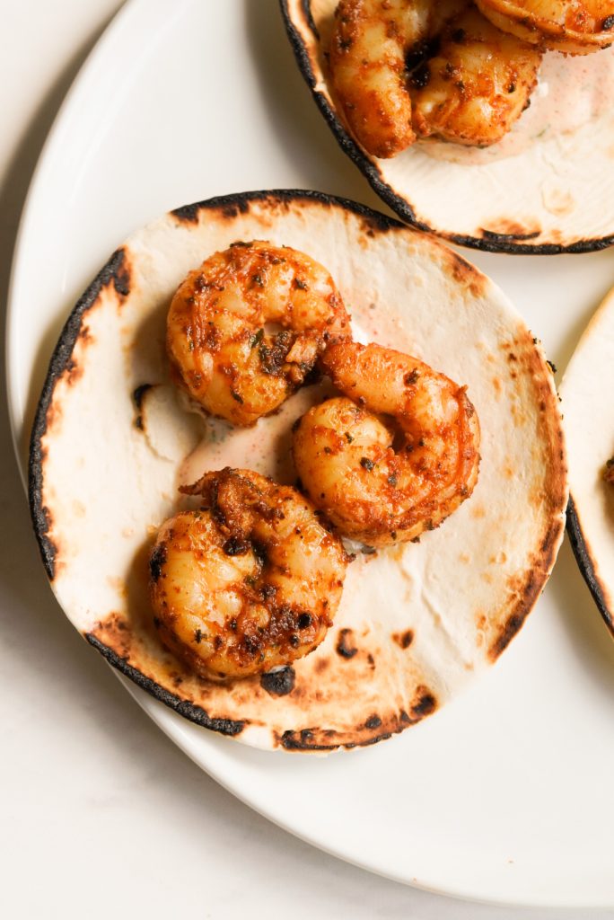 baja shrimp tucked into charred tortillas with cilantro lime crema.