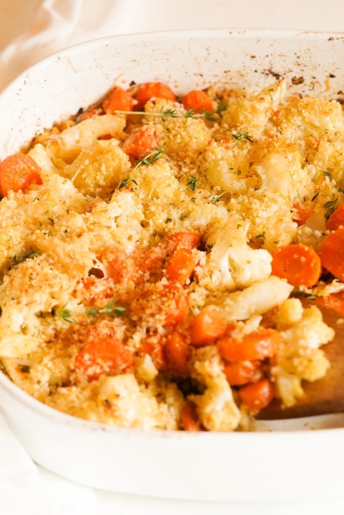 square white casserole dish with parmesan panko roasted carrots and cauliflower.