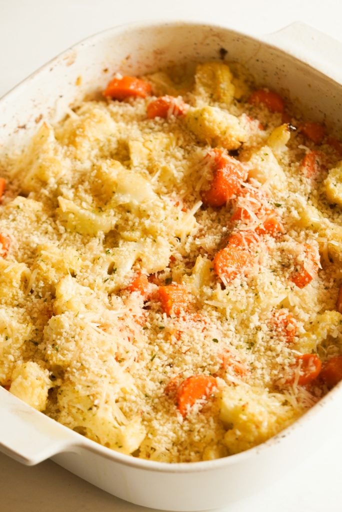 parmesan and panko breadcrumb topping added to the baking dish with the roasted cauliflower and carrots.