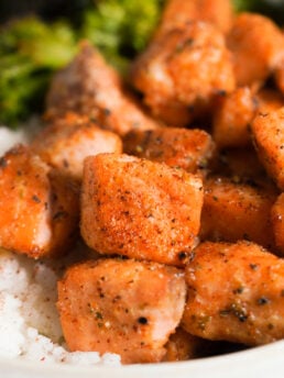 closeup shot of a plate of air fryer salmon bites with rice and broccoli.