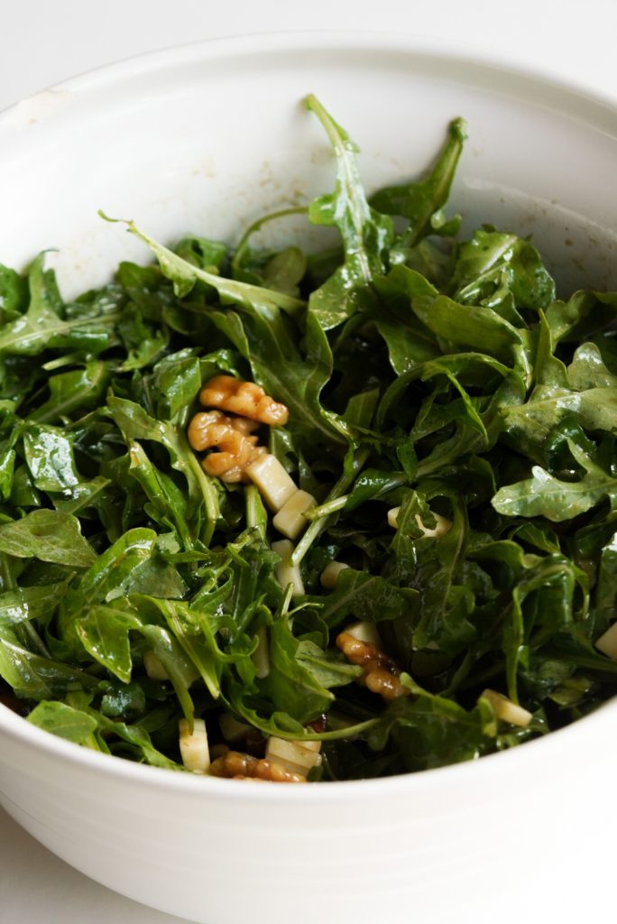 arugula salad after tossing with maple balsamic vinaigrette.