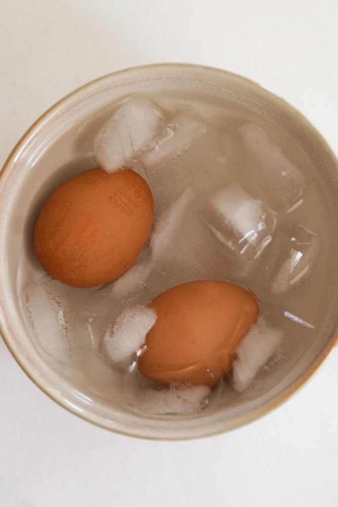 two boiled eggs in an ice bath