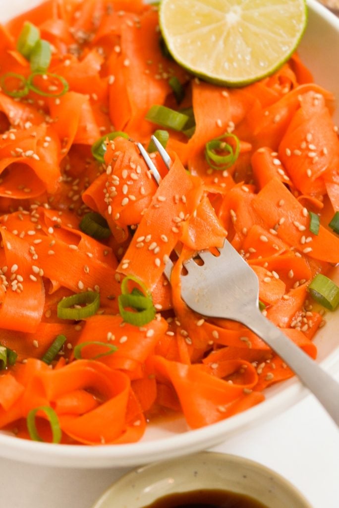 fork with raw carrot ribbons around it