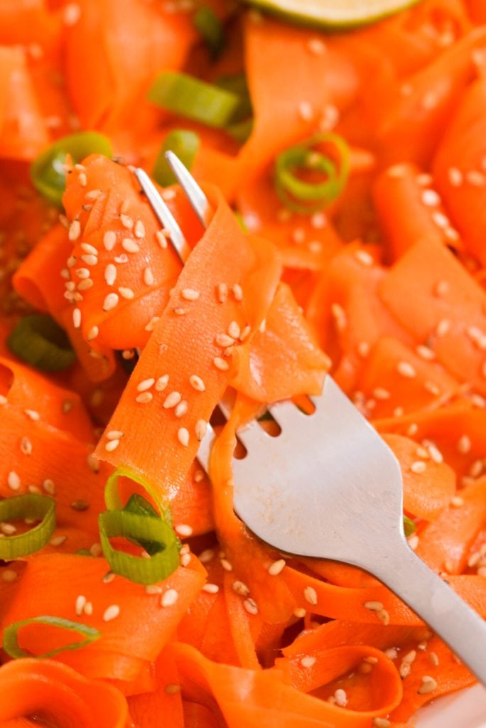 fork with raw carrot ribbons swirled around it