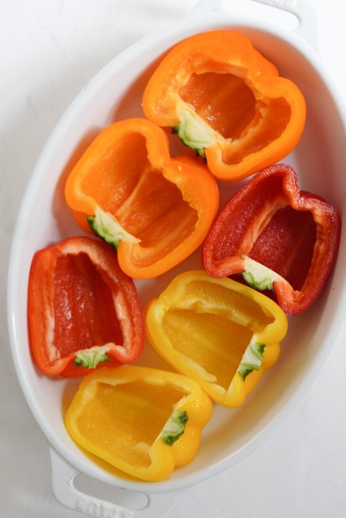 halved bell peppers in a baking dish.
