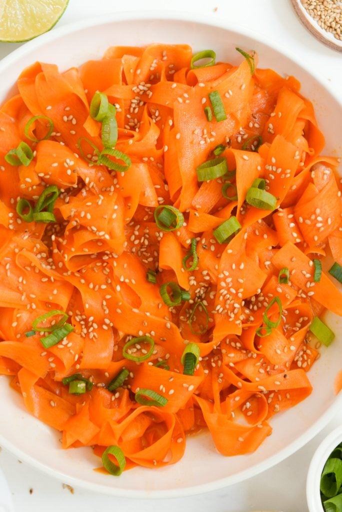 cold carrot salad with an Asian inspired dressing, sesame seeds, and green onions