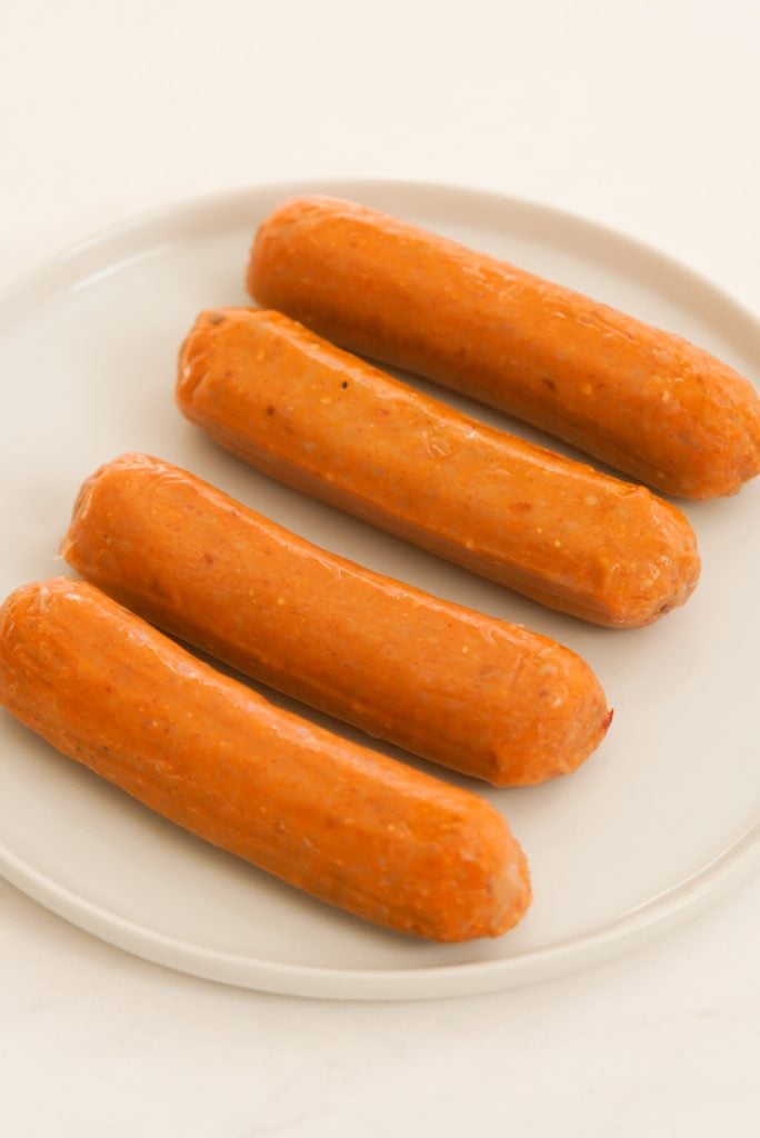chicken sausages on a plate before air frying