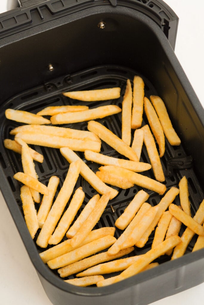 Frozen fries in the air fryer before cooking