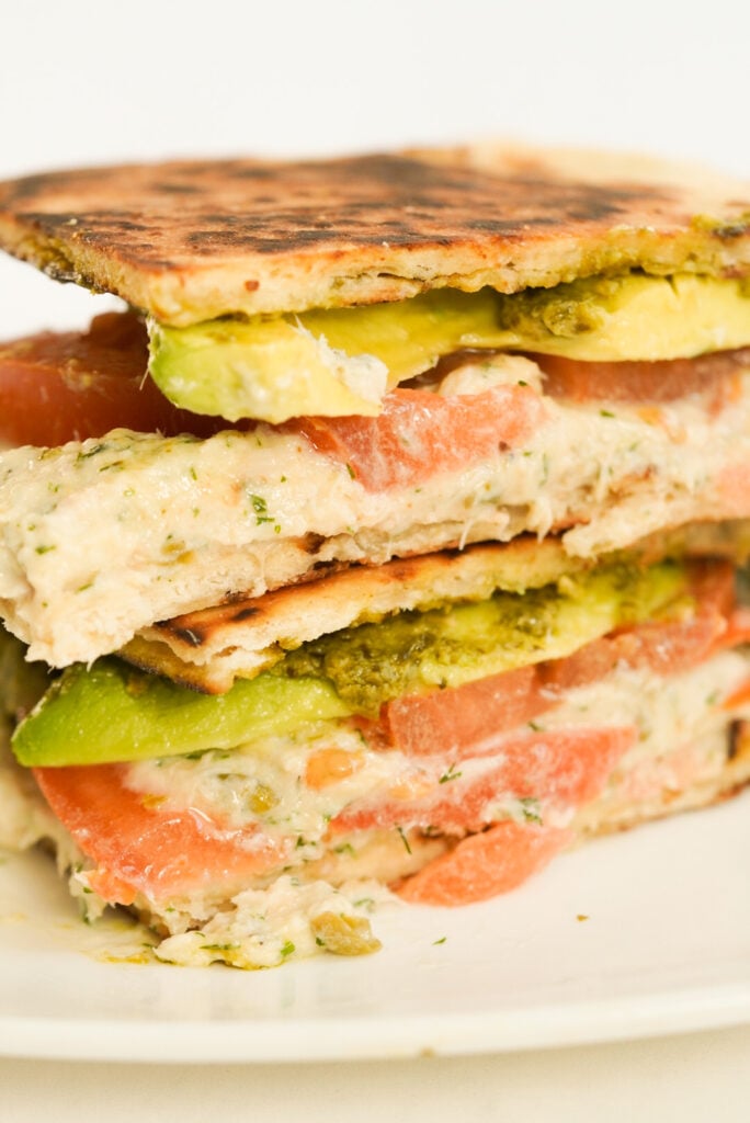 sandwich with avocado, pesto, tomato, and tuna mousse on flatbread