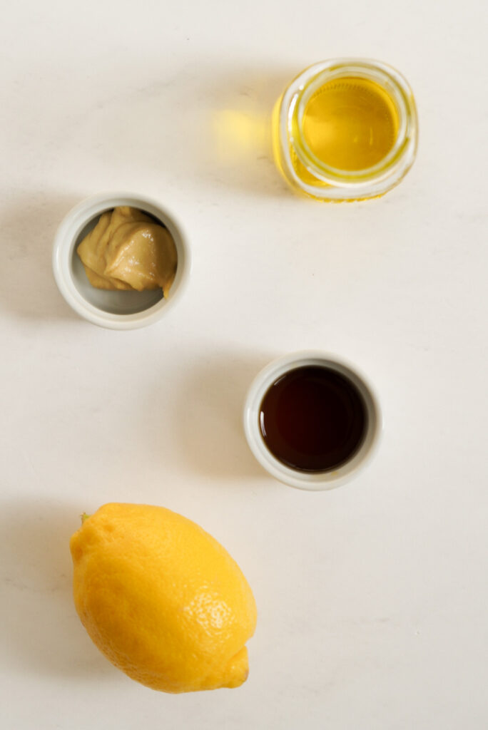Simple lemon vinaigrette ingredients measured out on a white surface