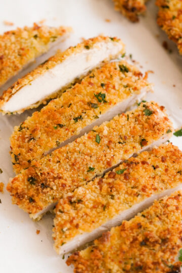 hero shot of an oven baked chicken cutlet that has been sliced into pieces to reveal the juicy insides.