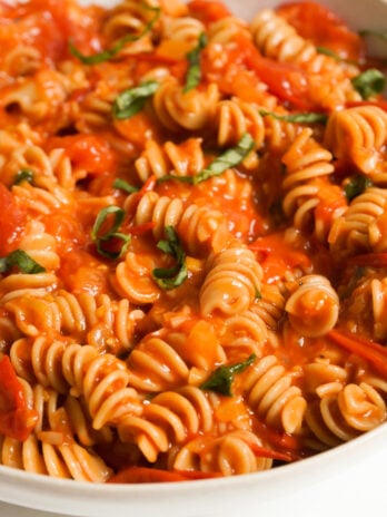 bowl of cherry tomato sauce pasta on a white table.