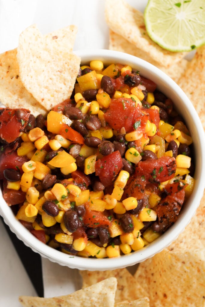 corn and black bean salsa with fire roasted tomatoes and canned black beans served with tortilla chips for dipping.