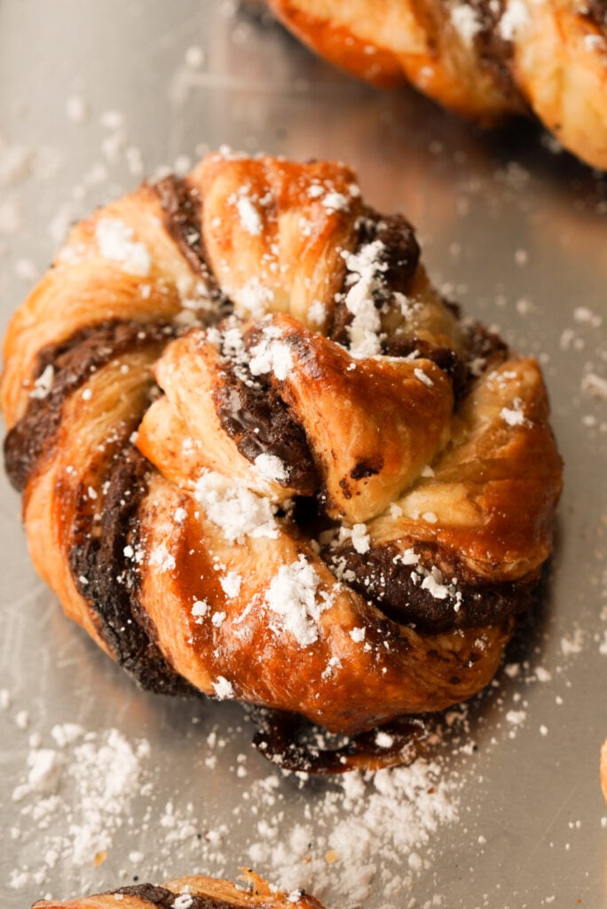puff pastry treat with chocolate topped with powdered sugar
