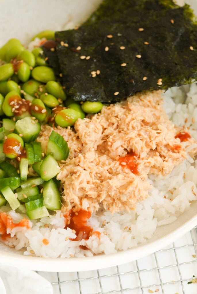 bowl of rice with a tuna mixture and fresh toppings