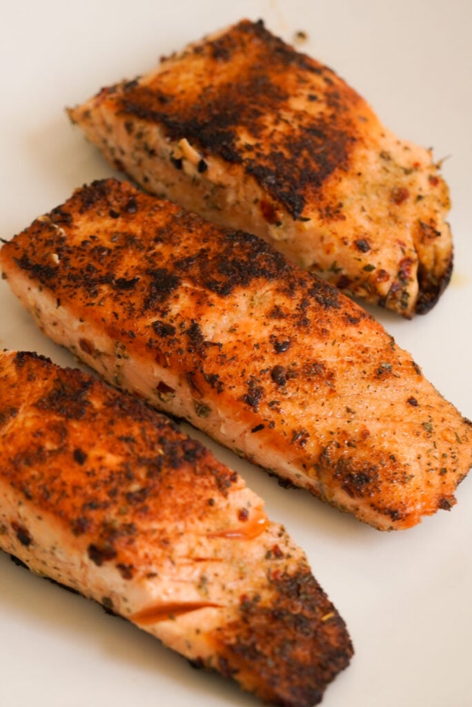 3 seared salmon fillets that are crispy brown.