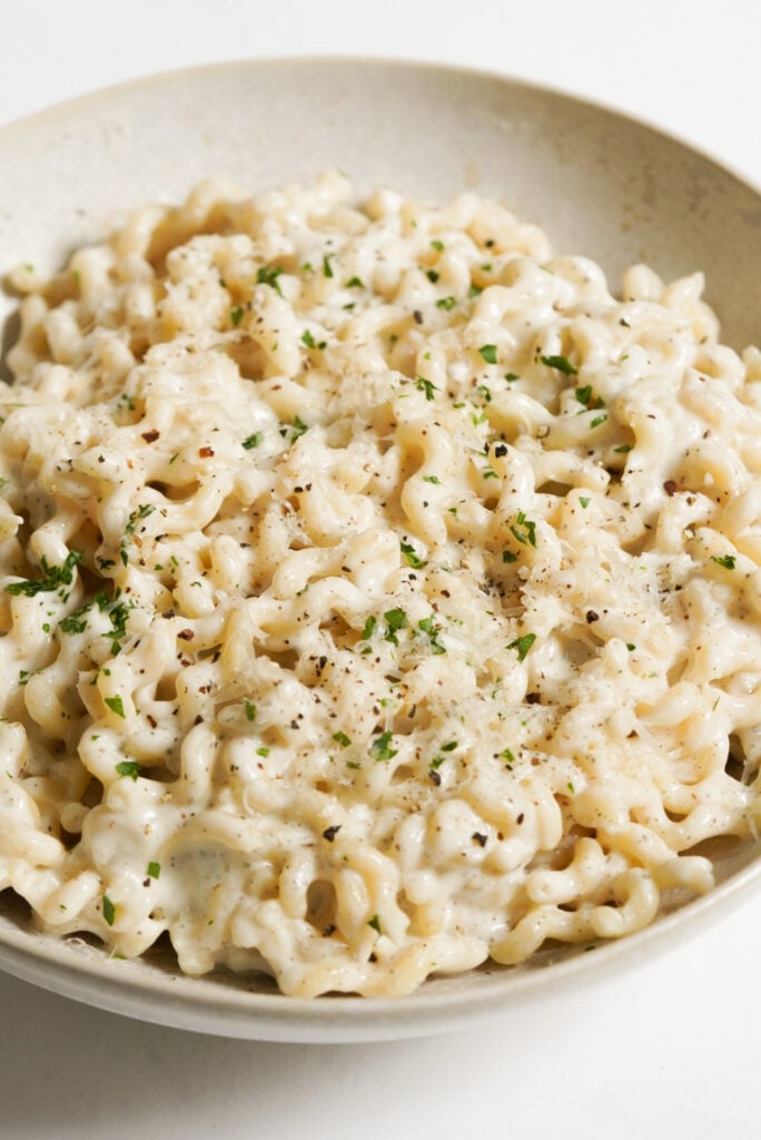 white serving bowl of cottage cheese pasta alfredo.