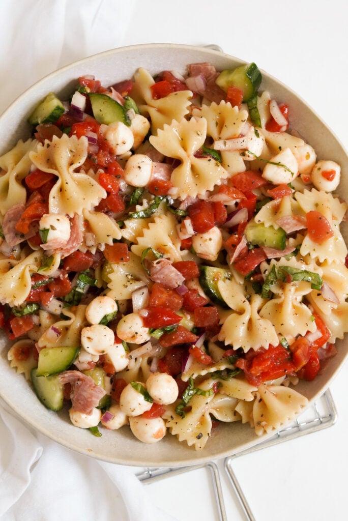 white bowl filled with bowtie pasta salad.