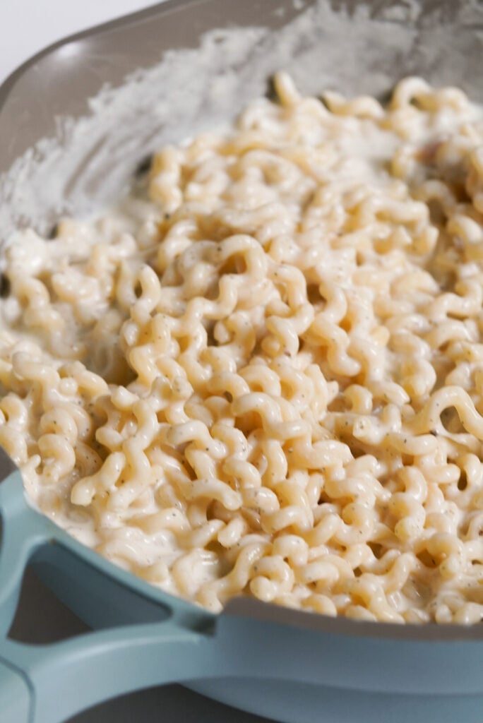 cottage cheese alfredo sauce with pasta in a blue skillet.