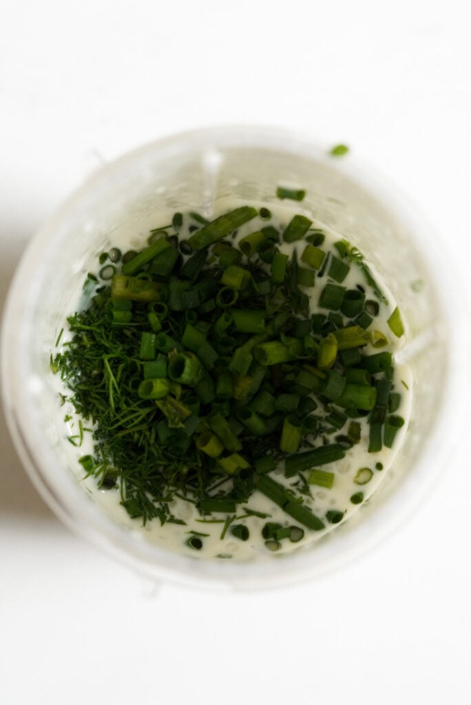 ingredients for greek yogurt dressing in the cup of a smoothie blender before blending.