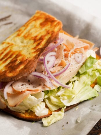 egg and cottage cheese flatbread folded over the turkey sandwich ingredients revealing the golden brown underside.