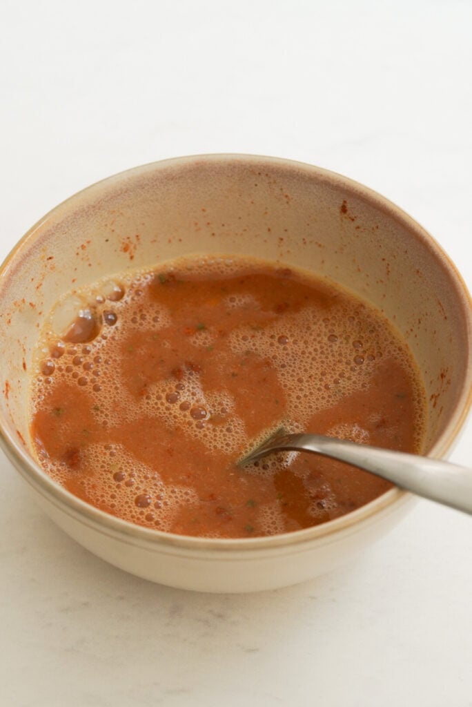 mixture of eggs and egg whites with taco seasoning in a small bowl after beating together with a silver fork.