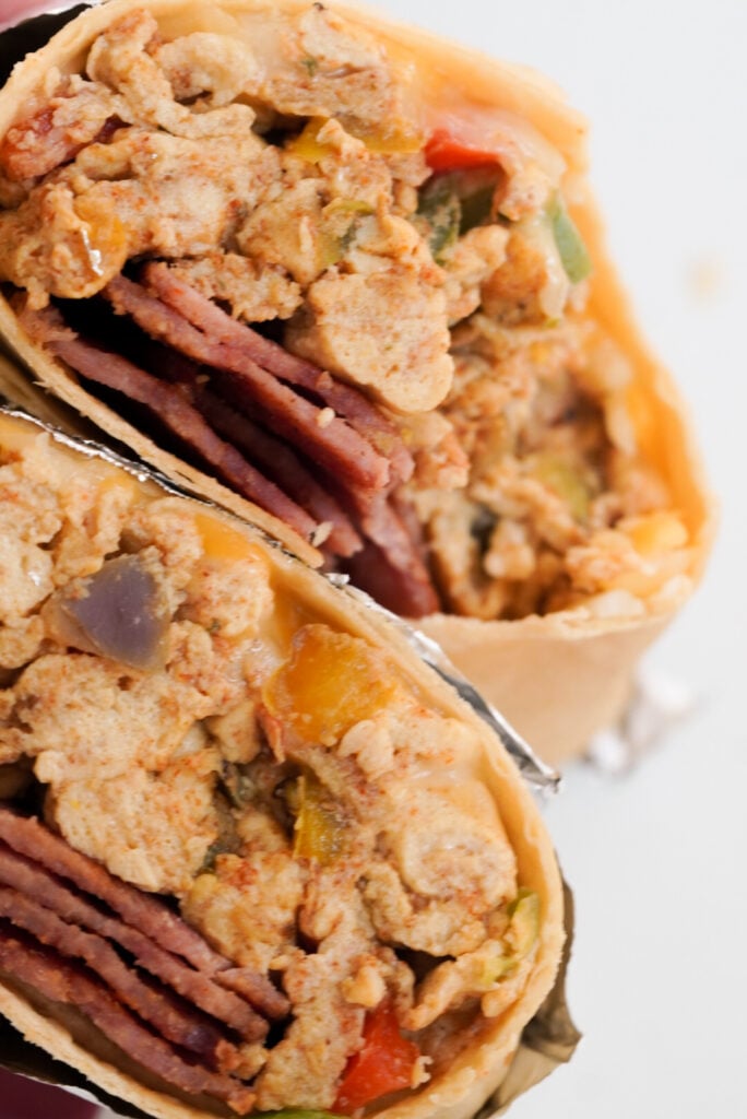 hyper closeup shot of a healthy high protein breakfast burrito with eggs and turkey bacon.