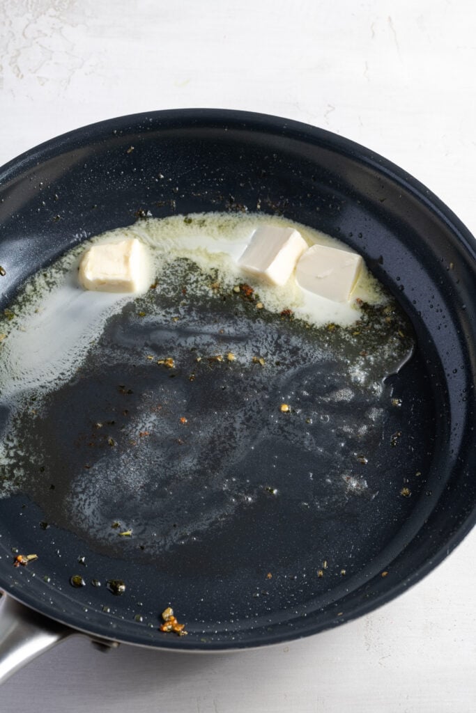 butter melting in a pan with oil and leftover fond from cooking the potatoes.