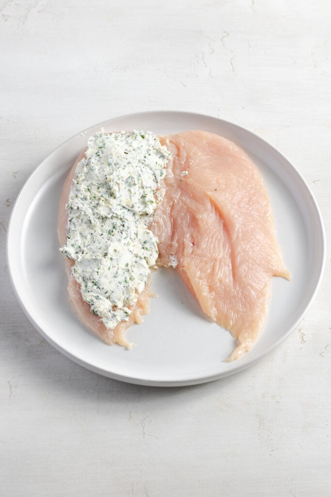 butterflied chicken breast with herb cream cheese spread across the left side.