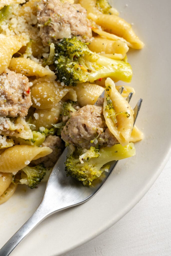 forkful of ground turkey pasta with broccoli florets.