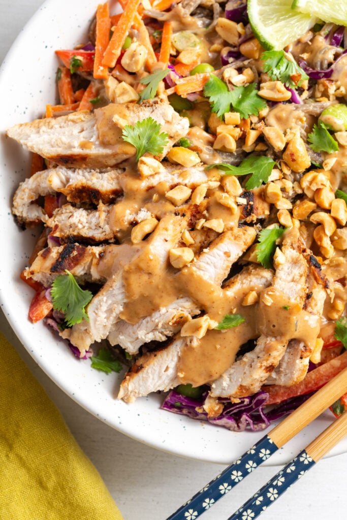 closeup overhead shot of the chicken atop the thai peanut noodle salad.