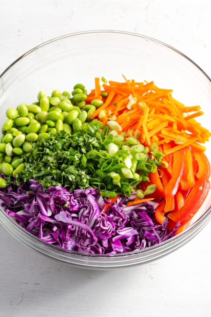 rainbow of raw veggies added to a mixing bowl.