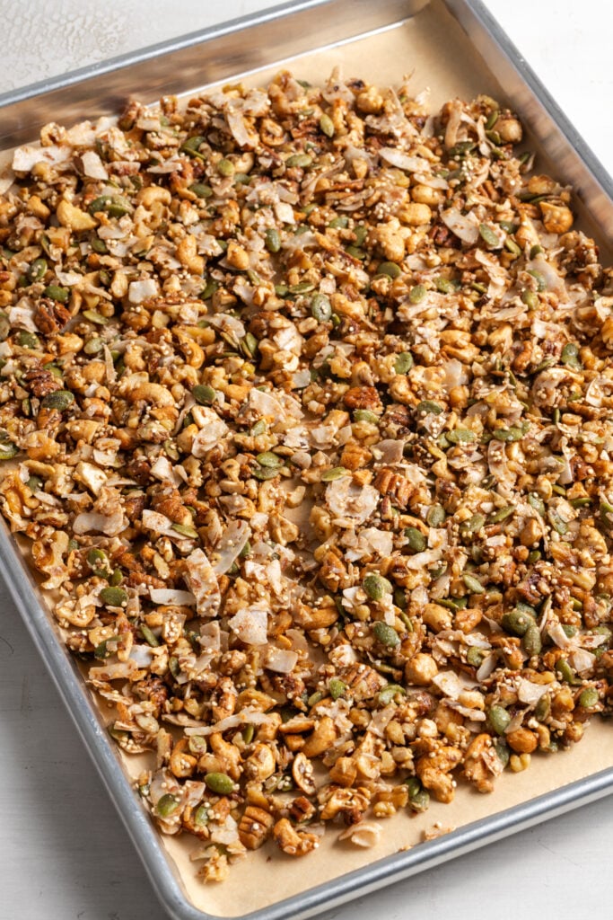 grain free granola on a parchment lined cookie sheet before baking.