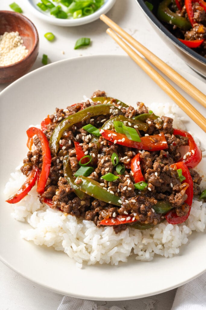 ground beef and pepper rice bowl after topping with scallion greens and toasted sesame seeds for garnish.