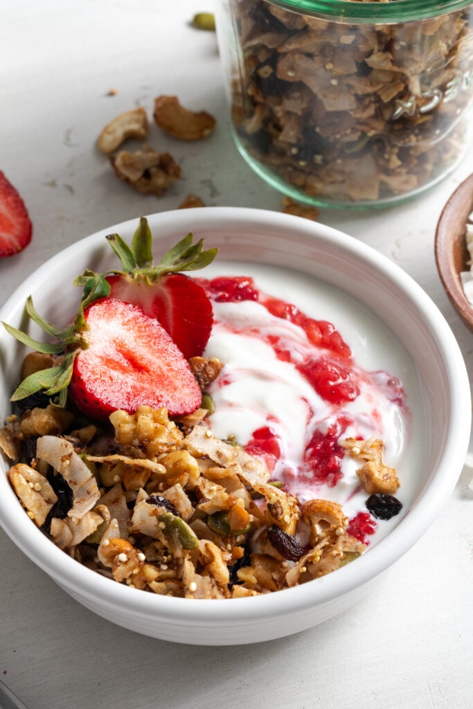 closeup shot of a yogurt parfait made with oat free grain free granola and fresh strawberries.