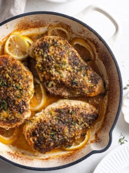 overhead shot of lemon pepper chicken breasts in a dutch oven after baking.