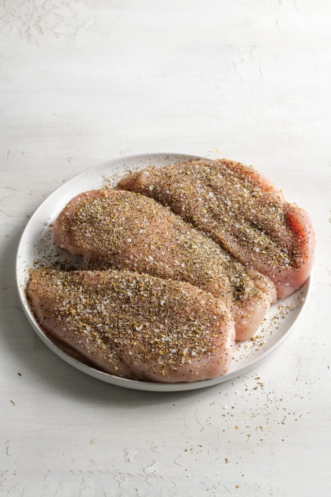 raw chicken breasts after sprinkling with seasoning.