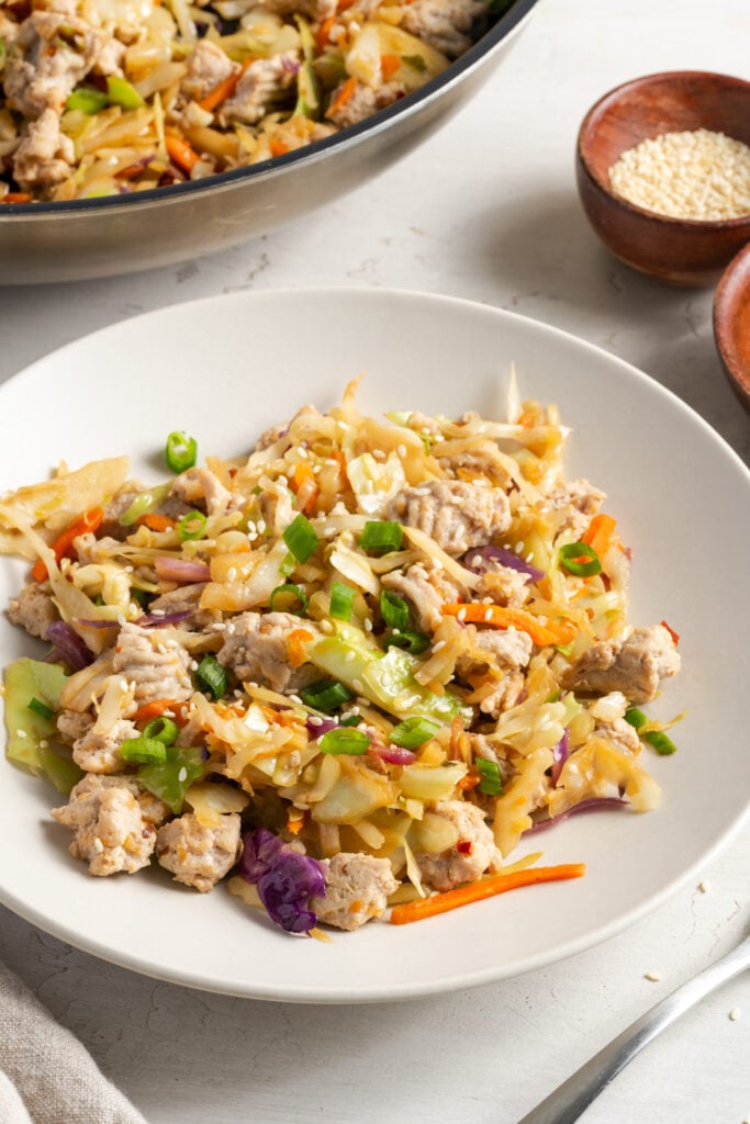 45 degree angle shot of a white pasta bowl filled with a serving of turkey egg roll in a bowl.